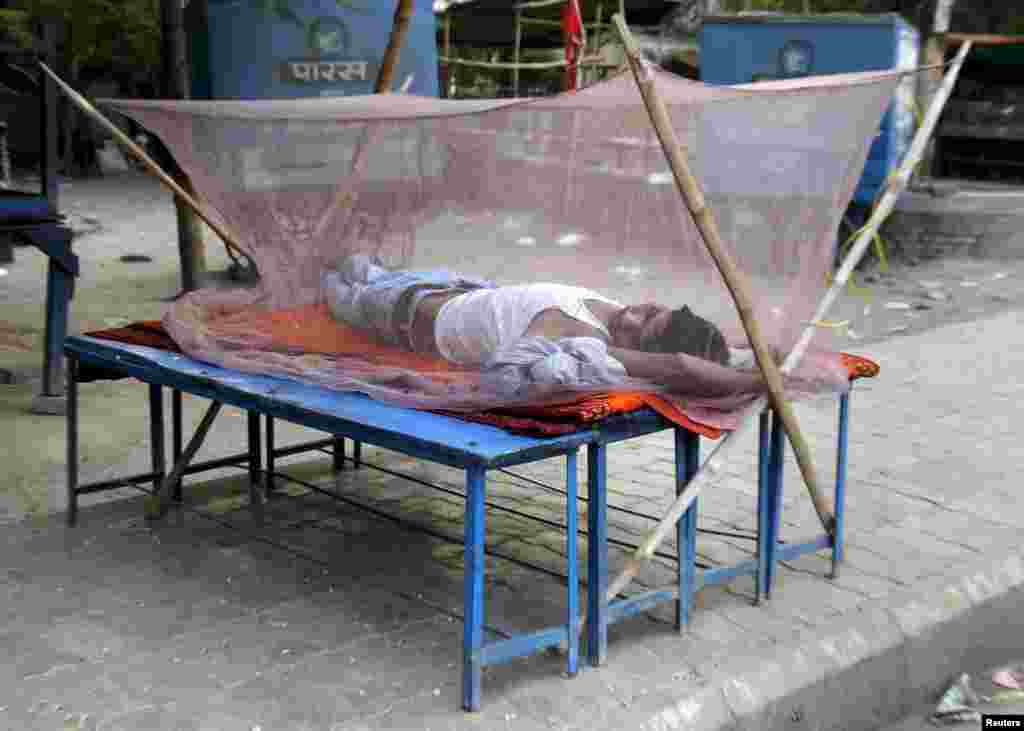 A man sleeps on a makeshift bed covered with a mosquito net on a hot summer morning in Allahabad where it is expected to reach 47 degrees Celsius according to India&#39;s metrological department,&nbsp;June 1, 2015.&nbsp; 