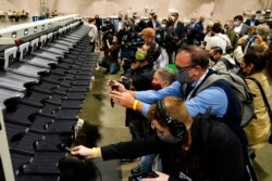 FILE - Media members photograph and record a sorting machine at Philadelphia's mail-in ballot sorting and counting center in preparation for the 2020 U.S. general election in Philadelphia, Oct. 26, 2020.