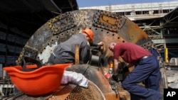 Работници поправаат дел од оштетената термоелектрана, една од најголемите во земјата, неодамна уништена од руски ракети во близина на Харкив, Украина, на 12 април 2024 година