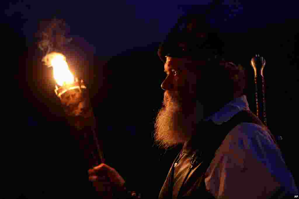 Al Thompson, of Milan, Ind., waits to announce his clan's arrival during the opening torchlight service of the 64th annual Grandfather Mountain Highland Games at MacRae Meadows in Linville, N.C., July 11, 2019. The games celebrate the history and culture 