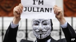 A supporter of WikiLeaks founder Julian Assange holds up a placard outside the Ecuadorian Embassy in central London, London, August 16, 2012.