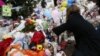 A woman puts a photo of a child on a makeshift memorial in the Sandy Hook Village of Newtown, Conn., as the town mourns victims killed in a school shooting, Dec. 17, 2012.