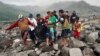 Rescuers and villagers carry a body bag containing the remains of a victim in the eruption of Mount Semeru, in Candi Puro village, Lumajang, East Java, Indonesia, Dec. 7, 2021. 