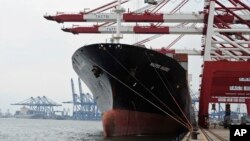 FILE - Containers are loaded onto a cargo ship at the Tianjin port in China. 