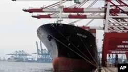 FILE - Containers are loaded onto a cargo ship at the Tianjin port in China. 