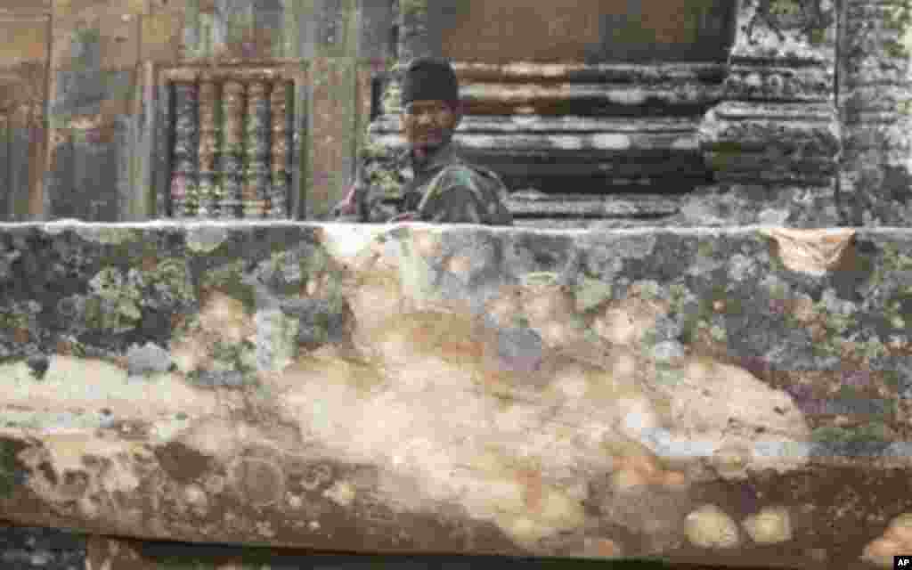 A Cambodian army soldier sits at damaged Cambodia's 11th century Hindu Preah Vihear temple.