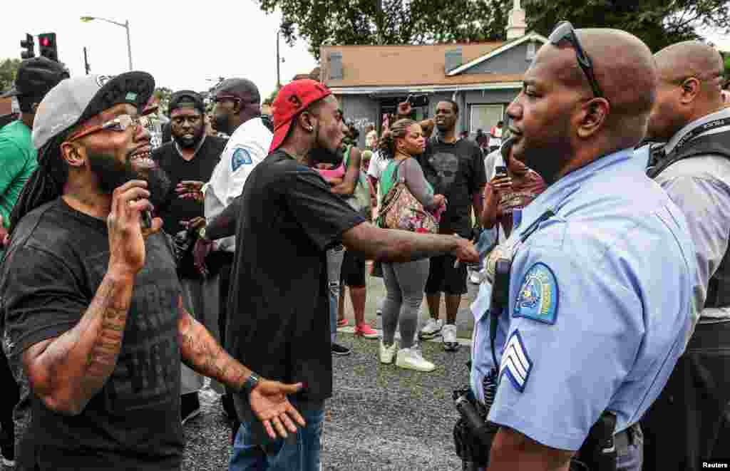 Area residents talk to police after a shooting incident in St. Louis, Aug. 19, 2015.