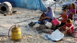 Seorang perempuan Palestina memeriksa barang-barangnya di samping anak-anak setelah serangan Israel di kamp tenda yang menampung orang-orang terlantar di Al-Mawasi, Khan Younis, Jalur Gaza, pada 10 September 2024. (Foto: Reuters)