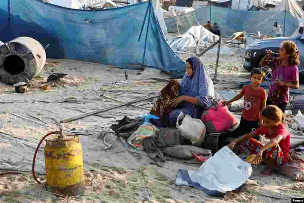 Una mujer palestina revisa sus pertenencias junto a unos niños tras los ataques israelíes contra un campamento de tiendas de campaña para personas desplazadas, en el área de Al-Mawasi en Khan Younis, en el sur de la Franja de Gaza el 10 de septiembre de 2024.