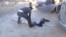  A still image taken from a video posted to a social media website on April 4, 2017, shows a man lying on the ground and being sprayed with water, said to be in the town of Khan Sheikhoun.