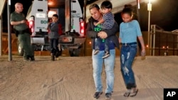 FILE - A Honduran man carries his 3-year-old son as his daughter and other son follow to a transport vehicle after being detained by U.S. Customs and Border Patrol agents in San Luis, Ariz., July 18, 2018. Border arrests figures for August 2018 are the latest reminder of how crossings have shifted over the last decade from predominantly Mexican men to Central American families and children.