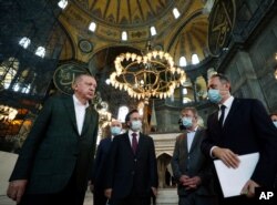 El presidente de Turquía, Recep Tayyip Erdogan (izquierda), escucha a un funcionario durante una visita a la Hagia Sophia, la catedral de la era bizantina, que es una de las principales atracciones turísticas de Estambul. Julio 19 de 2020.
