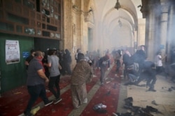 FILE - Palestinians clash with Israeli security forces at the Al-Aqsa mosque compound in Jerusalem's Old City, May 10, 2021.