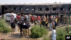 Para prajurit dan pejabat Pakistan memeriksa gerbong kereta yang rusak terbakar di Liaquatpur, Pakistan, Kamis, 31 Oktober 2019. (Foto AP / Siddique Baluch)