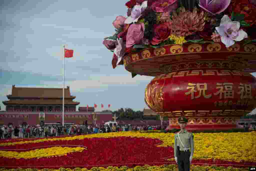 A paramilitary soldier stands in front of a giant flower bouquet that stands on Tiananmen Square in honor of the the upcoming Chinese National Day in Beijing.