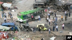  In this photo released by the Syrian official news agency SANA, Syrians inspect damages after a bombing attack at a bus station, in the coastal town of Tartus, Syria, Monday, May 23, 2016. 