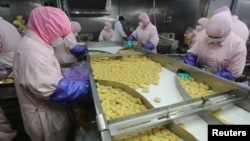 Employees work at the Husi Food factory prior to a seizure from the Shanghai Food and Drug Administration July 20, 2014. 