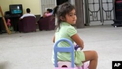 FILE - three-year-old Perla Calidono, of Copan, Honduras, plays at the Nuestra Senora de Guadalupe migrant shelter in Reynosa, Mexico. 