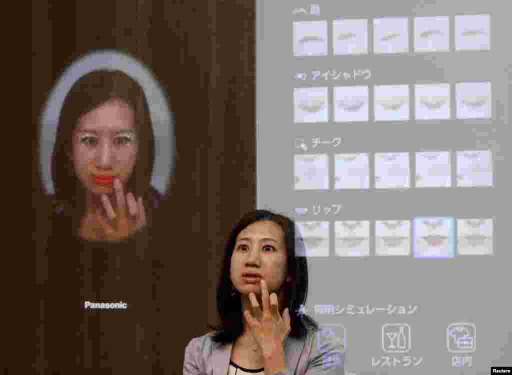 A woman is reflected in Panasonic Corp&#39;s interactive mirror, which is able to apply virtual makeup and detect skin condition, during a demonstration at CEATEC (Combined Exhibition of Advanced Technologies) JAPAN 2015 in Makuhari, Japan.