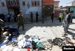 FILE - Clothes and sandals are seen at the site of a suicide bomb attack in Kabul, Afghanistan, April 22, 2018.