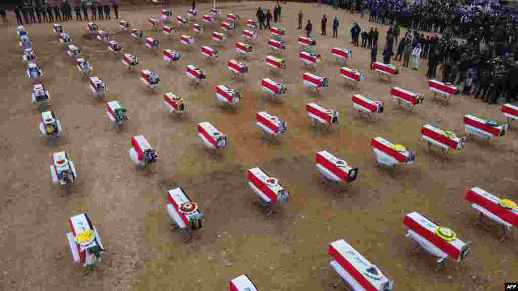 An aerial picture shows mourners gathering around coffins wrapped with the Iraqi flag during a mass funeral for Yazidi victims of the Islamic State (IS) group in the northern Iraqi village of Kojo in Sinjar district, Feb. 6, 2021.