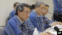 Tokyo Electric Power Co. (TEPCO) President Masataka Shimizu, left, attends a news conference with TEPCO Executive Toshio Nishizawa, center, on its fiscal 2010 earning at the company's head office in Tokyo, May 20, 2011