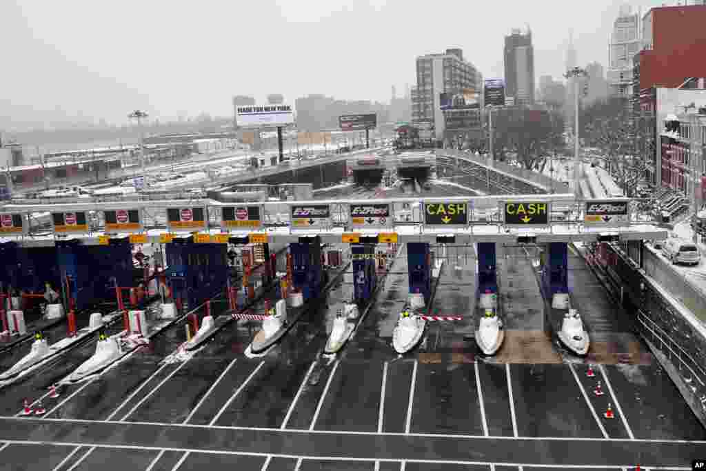 A single car enters the Manhattan-bound tube of the Midtown Tunnel after passing through an empty toll plaza during the morning commute following a winter storm in the Queens borough of New York, Jan 27, 2015.