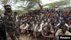 Members of al Qaida-linked militant group al Shabab listen to a Somalia government soldier after their surrender to the authorities in the north of Somalia's capital Mogadishu, September 24, 2012.