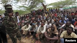 FILE - Members of al Qaida-linked militant group al Shabab listen to a Somalia government soldier after their surrender to the authorities in the north of Somalia's capital Mogadishu, Sept. 24, 2012.