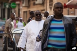 FILE - Papa Massata Diack, center, son of former IAAF President Lamine Diack, arrives at the central police station in Dakar, Senegal, Feb. 17, 2016.