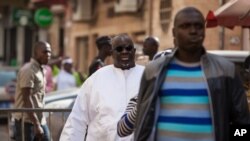 FILE - Papa Massata Diack, center, son of former IAAF president Lamine Diack, arrives at the central police station in Dakar, Senegal, Feb. 17, 2016. 