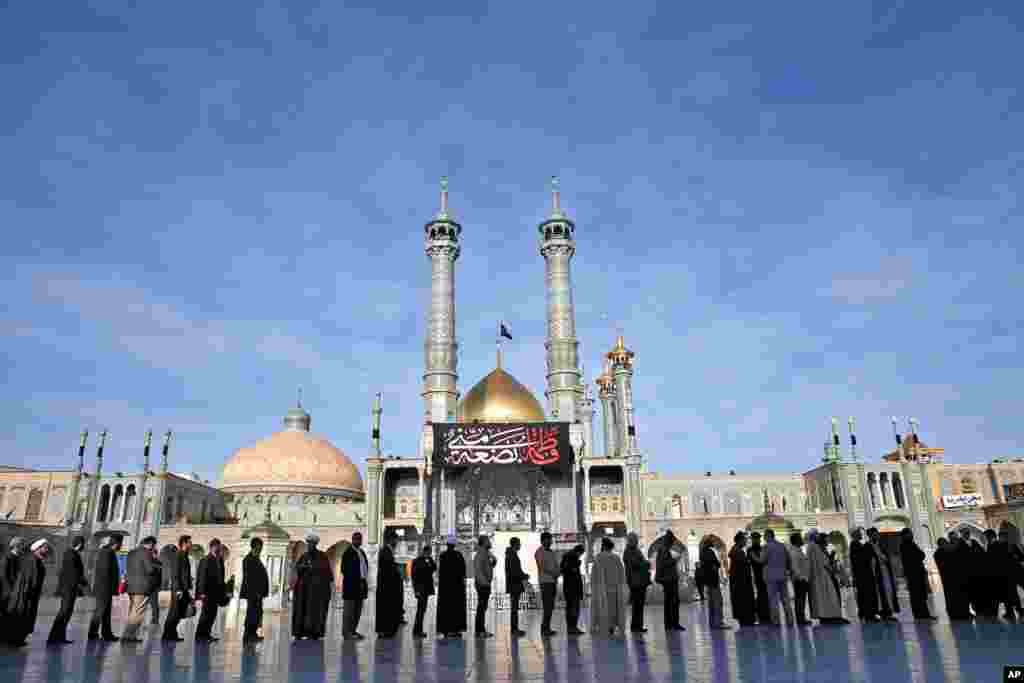 Iranians stand in line at a polling station during the parliamentary and Experts Assembly elections in Qom, Friday, Feb. 26, 2016.