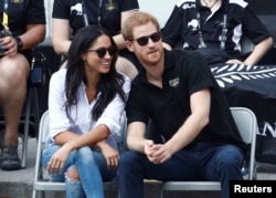 Britain's Prince Harry sits with girlfriend actress Meghan Markle to watch a wheelchair tennis event during the Invictus Games in Toronto, Sept. 25, 2017.