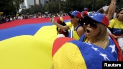 FILE - People carry a giant Venezuelan flag during a protest of Venezuelan citizens residing in Mexico, against the government of Venezuela's President Nicolas Maduro and the violence resulting from anti-government protests, in Mexico City, Feb. 23, 2014.