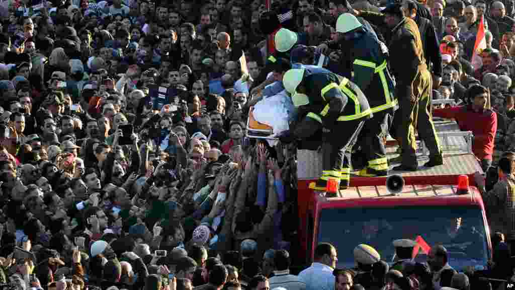 Egyptians carry the coffin of a victim killed in an explosion at a police headquarters in the Nile Delta city of Mansoura, Egypt, Dec. 24, 2013.