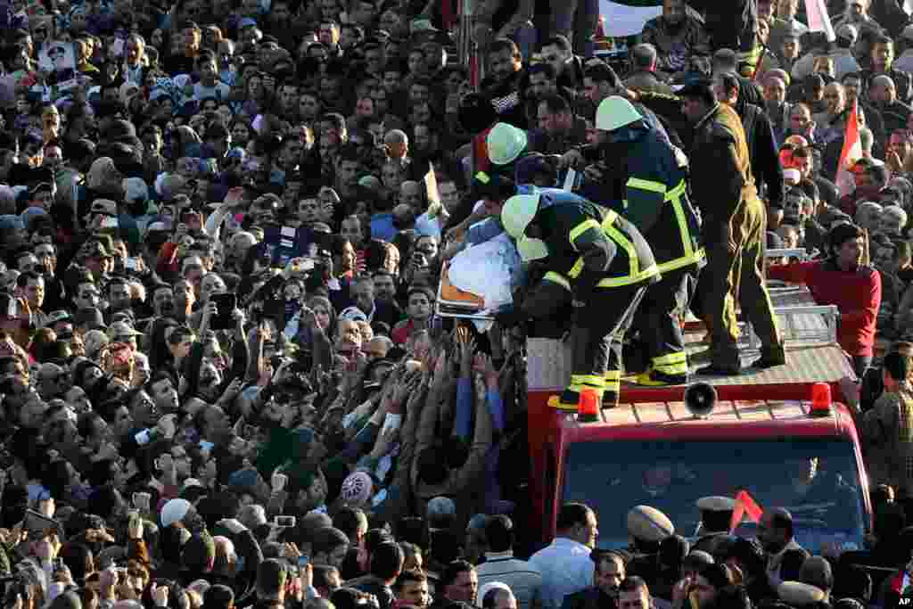 Egyptians carry the coffin of a victim killed in an explosion at a police headquarters in the Nile Delta city of Mansoura, Egypt, Dec. 24, 2013.