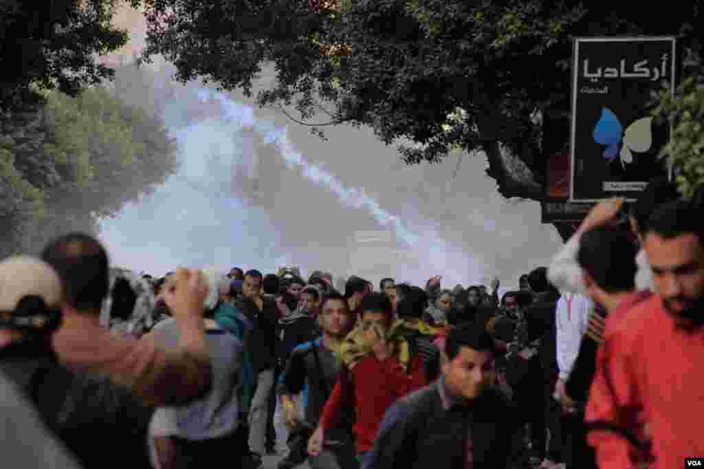 Protesters run after police fired tear gas in Cairo, Dec. 6, 2013. (Hamada Elrasam for VOA)