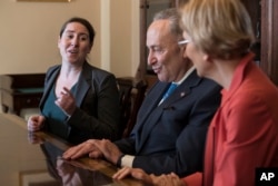 From left, Leandra English, who was elevated to interim director of the Consumer Financial Protection Bureau, meets with Senate Minority Leader Chuck Schumer, D-N.Y., and Sen. Elizabeth Warren, D-Mass., in Washington, Nov. 27, 2017.