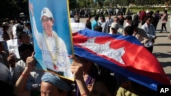 Một người ủng hộ đảng đối lập Cứu quốc Campuchia (CNRP) dâng cao tấm ảnh của người đứng đầu đảng Kem Sokha trong một cuộc tuần hành tại Phnom Penh hôm 26/9. Ông Kem Sokha bị bắt vì cáo buộc phản quốc. Liên minh châu Âu quyết định tạm ngừng cung cấp tài chính cho cuộc bầu cử vào năm sau của nước này. 