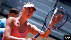 FILE - Russian tennis player Maria Sharapova touches her racket at the end of her match against Colombian Mariana Duque Marino in Madrid, May 5, 2015. 
