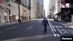 A lone man crosses 5th Ave following the outbreak of coronavirus disease (COVID-19), in the Manhattan borough of New York City, New York, U.S., March 24, 2020.