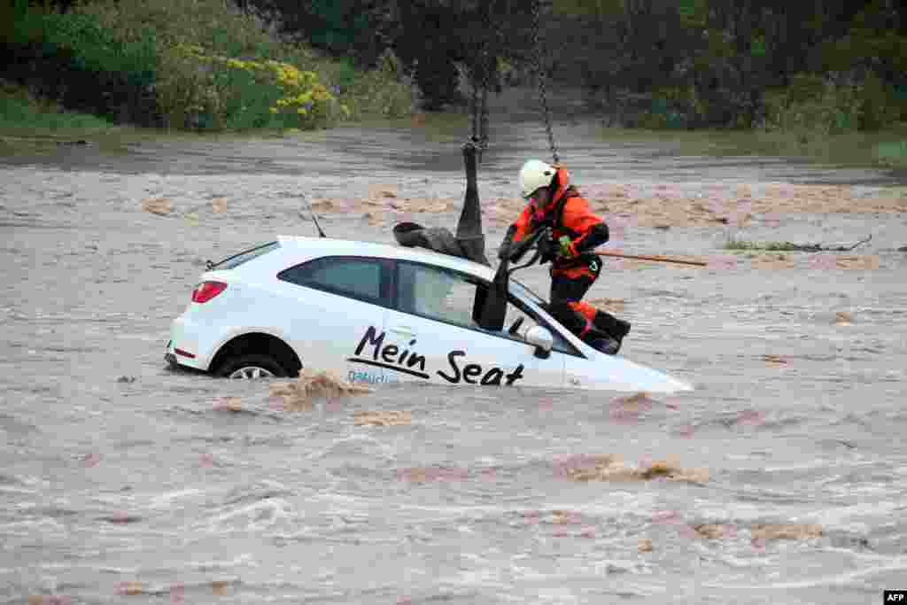 A rescue worker attaches a strap to pull a car out of over-flooded areas of the river Leine in Goettingen, central Germany.