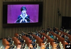 FILE - South Korean President Park Geun-hye, shown on a large screen, delivers a speech at the National Assembly in Seoul, South Korea, Oct. 24, 2016.