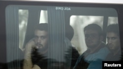 New Syrian refugees look out from their bus as they arrive at a refugee camp in the Turkish border town of Reyhanli in Hatay province July 29, 2012.