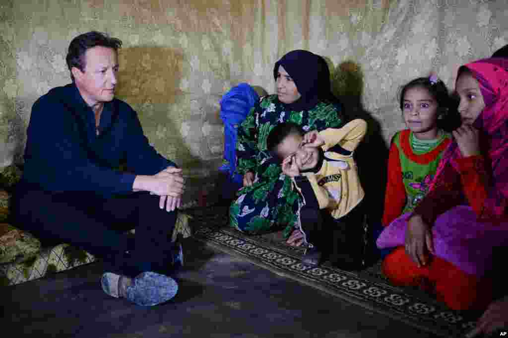 British Prime Minister David Cameron meets Syrian refugee families at a settlement camp in the Bekaa Valley on the Syrian-Lebanese border.