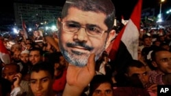 Mohamed Morsi has been ousted as president of Egypt, and his supporters, one holding a Morsi mask, are demanding his reinstatement. 