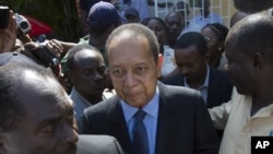 Former Haitian dictator Jean-Claude Duvalier, center, leaves Canape Vert Hospital in Port-au-Prince, Haiti, March 29, 2011