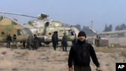 In this image taken from video obtained from the Ugarit News, which has been authenticated based on its contents and other AP reporting, Syrian rebels capture a helicopter air base near the capital Damascus after fierce fighting in Syria, on Sunday, Nov. 