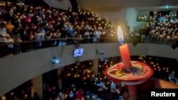 A man holds a candle at a prayer service on Christmas Eve at a church in Bandung, Indonesia, Dec. 24, 2017. Antara Foto/Novrian Arby/via Reuters