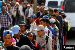 Migrants, part of a caravan of thousands trying to reach the U.S., stand in line for a free meal after arriving in Tijuana, Mexico, Nov. 13, 2018.